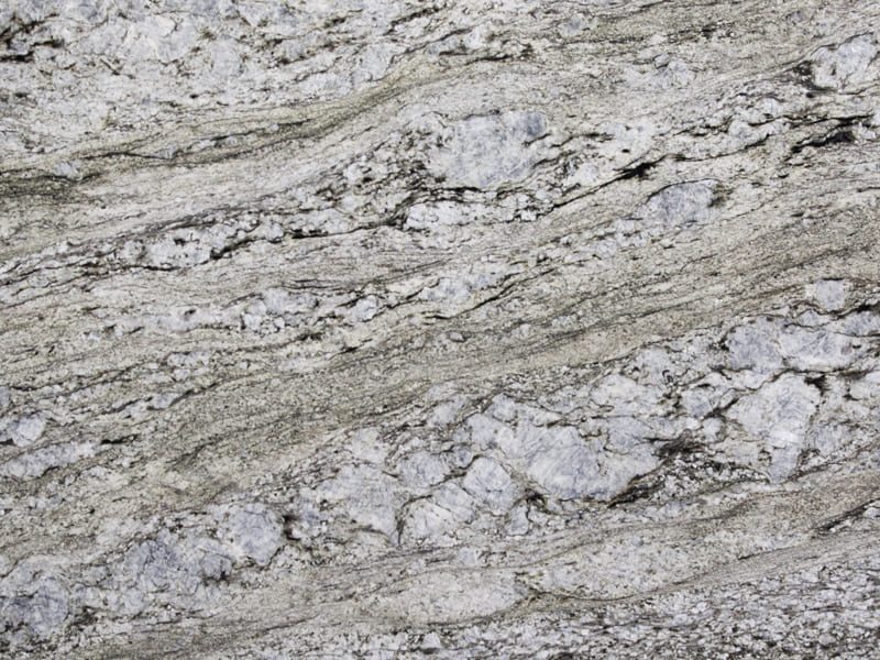 Blue Dunes Granite slab &mdash; blue-grey to steel-blue with flowing wave-pattern banding